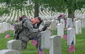 An American soldier visits the grave of a fallen soldier at Arlington National Cemetery.